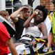 First responders help woman injured by the car attack on Saturday. Image via the AP.